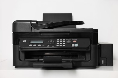 Modern printer on white table in office