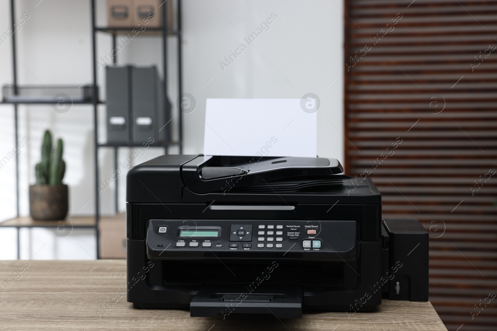 Photo of Modern printer with paper on table in office