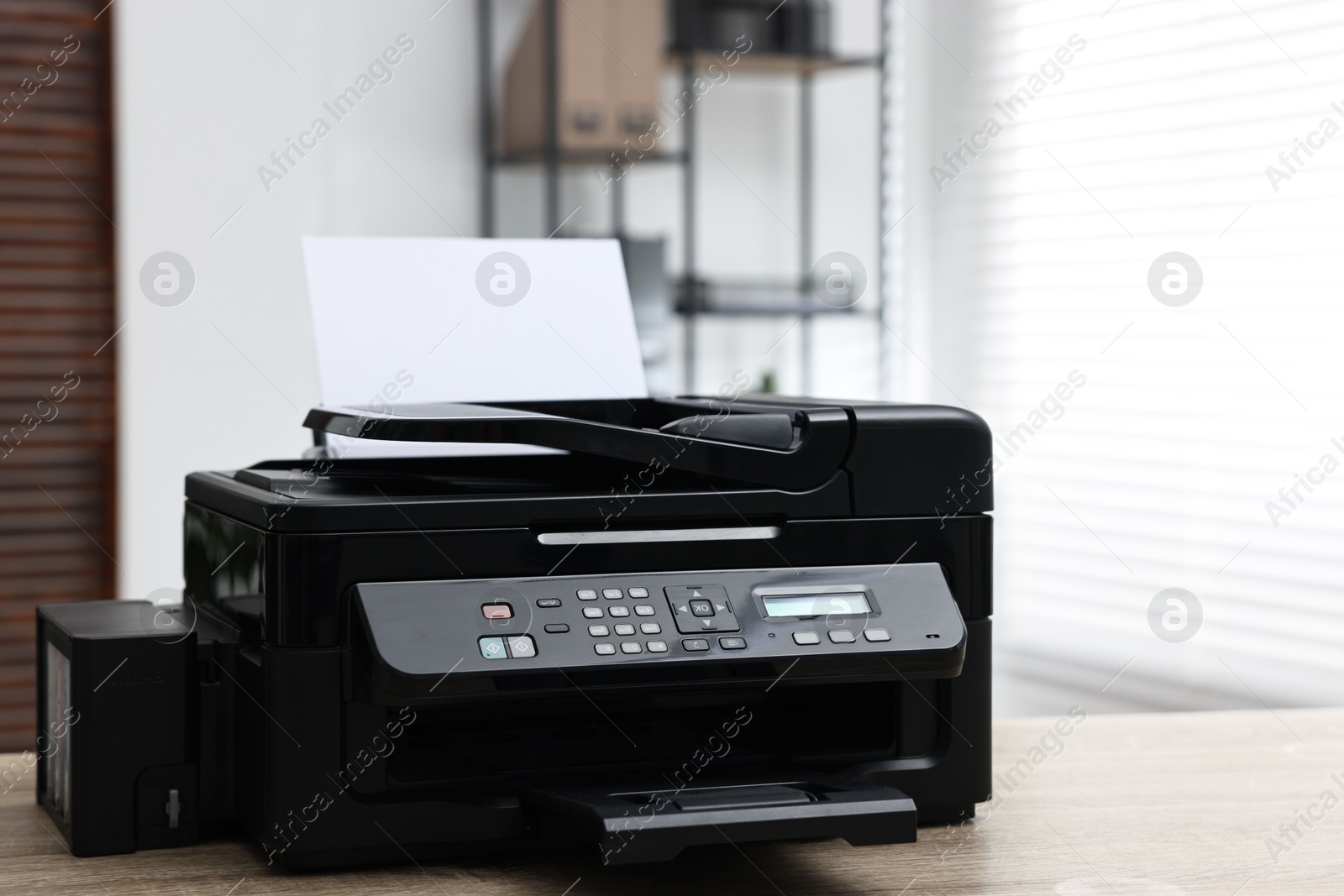 Photo of Modern printer with paper on table in office