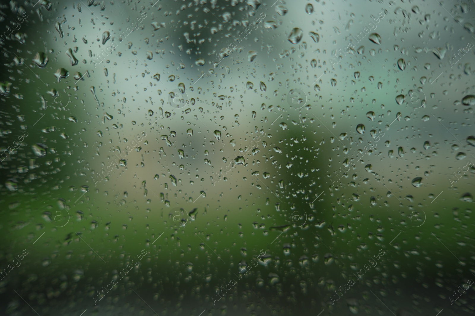 Photo of Window glass with water drops, closeup. Rainy weather