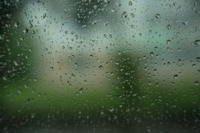 Photo of Window glass with water drops, closeup. Rainy weather
