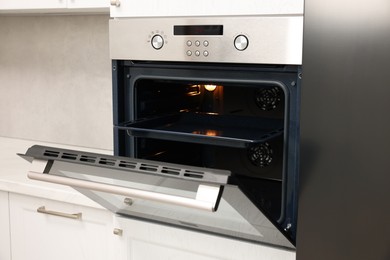 Photo of Open electric oven in kitchen. Cooking appliance