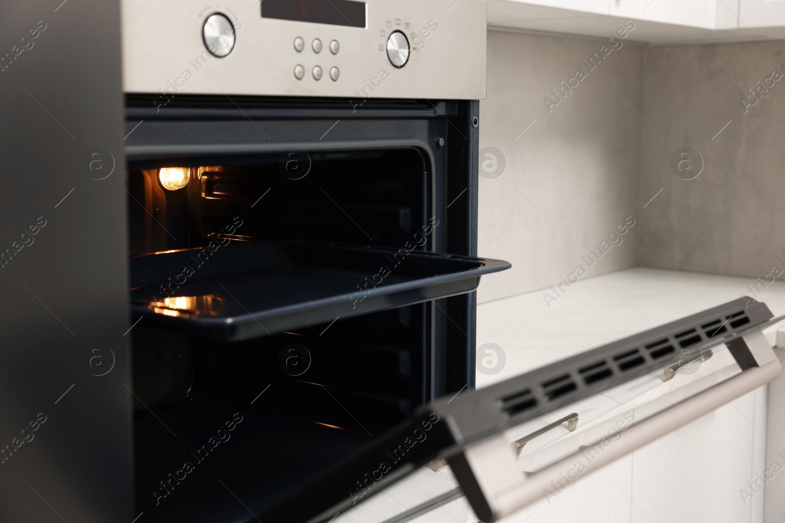 Photo of Open electric oven in kitchen. Cooking appliance