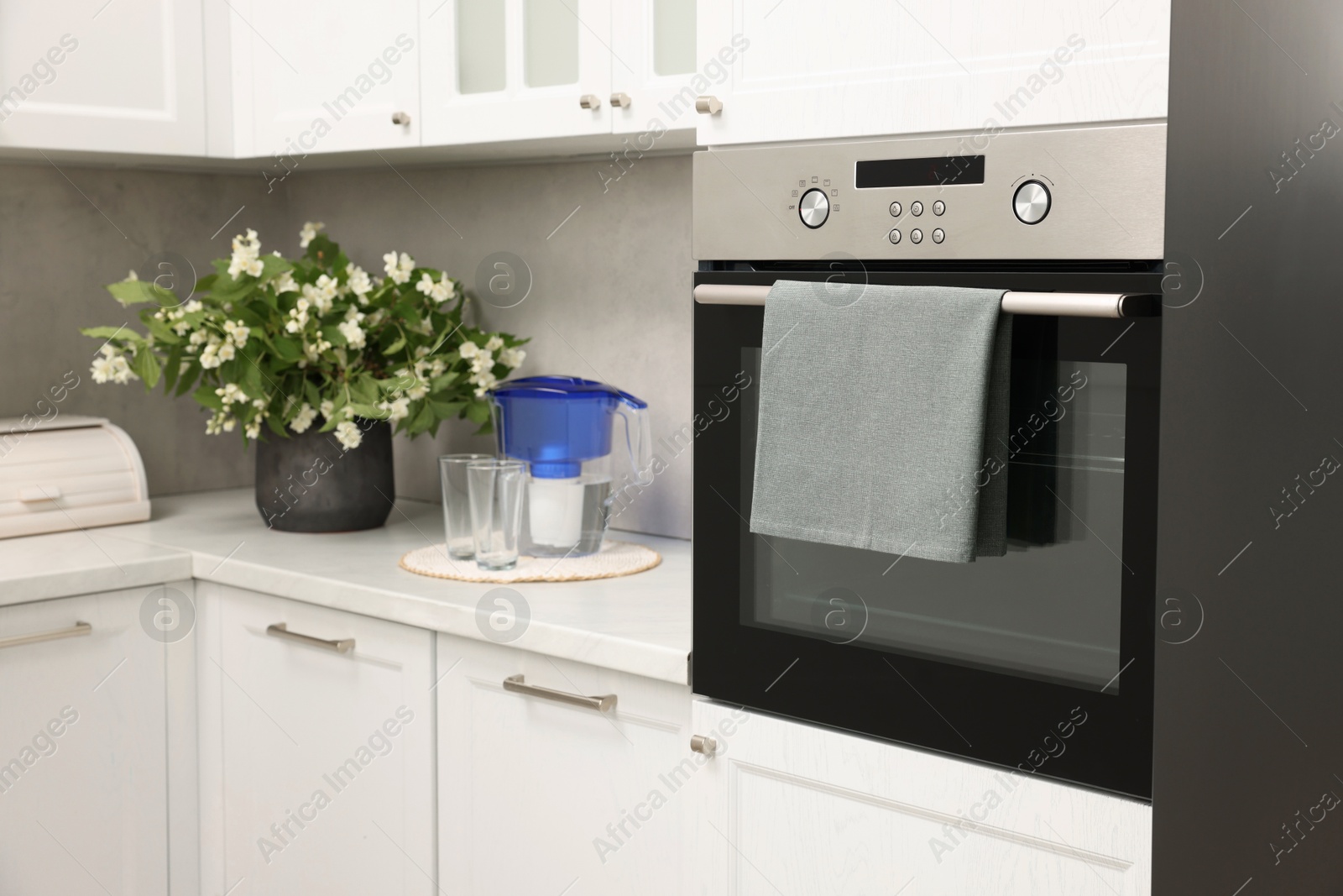 Photo of Electric oven with towel in kitchen. Cooking appliance