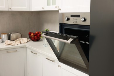 Photo of Open electric oven in kitchen. Cooking appliance