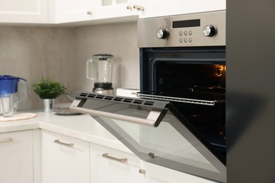 Photo of Open electric oven in kitchen. Cooking appliance