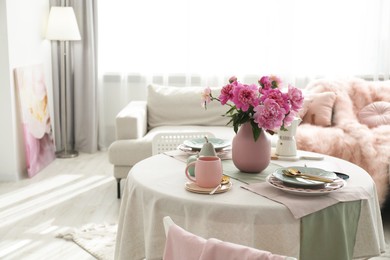 Photo of Beautiful table setting with pink peonies in living room. Space for text