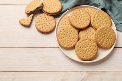 Photo of Fresh tasty sandwich cookies on wooden table, top view. Space for text