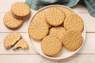 Photo of Fresh tasty sandwich cookies on wooden table, top view