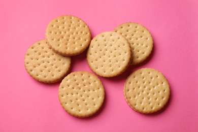 Photo of Tasty sandwich cookies on pink background, top view