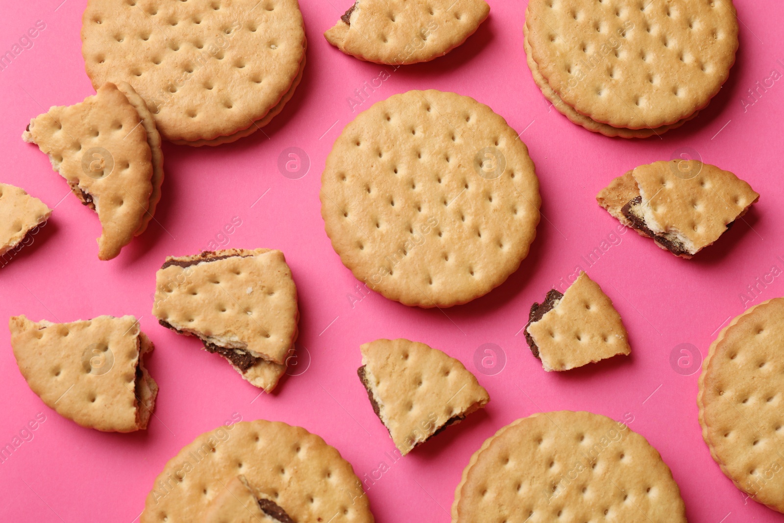 Photo of Tasty sandwich cookies on pink background, top view