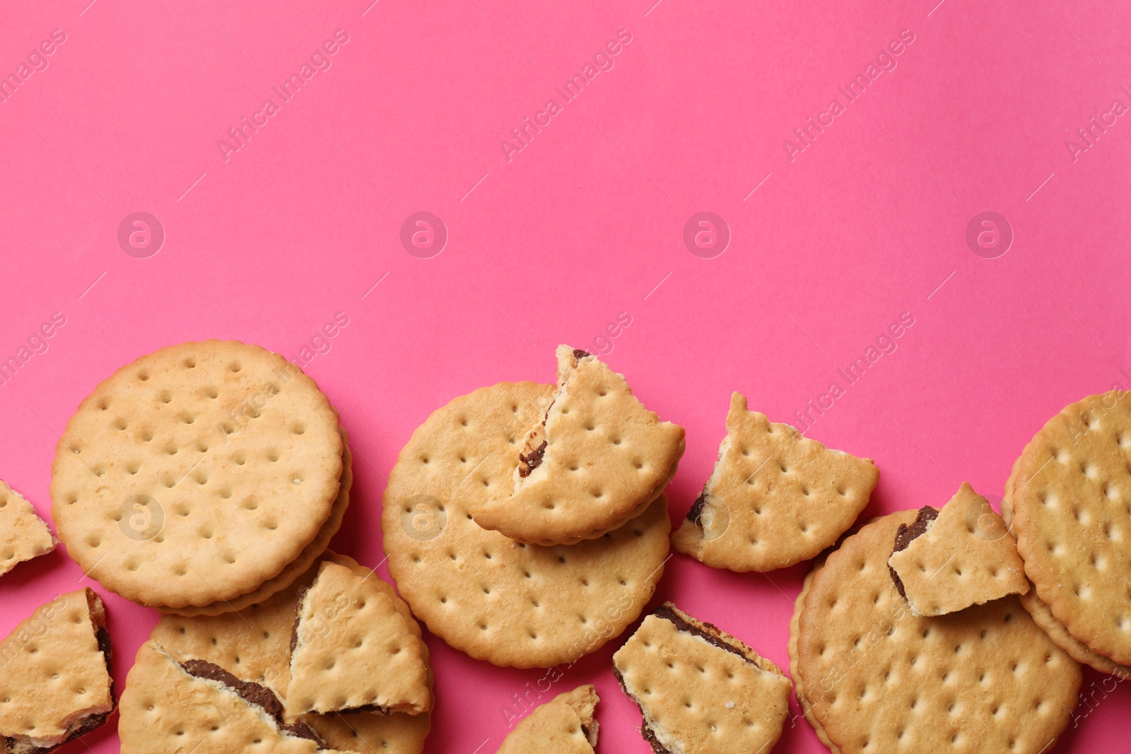 Photo of Tasty sandwich cookies on pink background, top view. Space for text