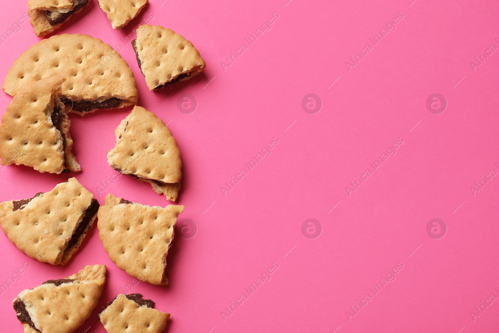 Photo of Tasty sandwich cookies on pink background, top view. Space for text