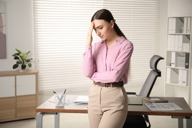 Photo of Embarrassed woman near wooden table in office