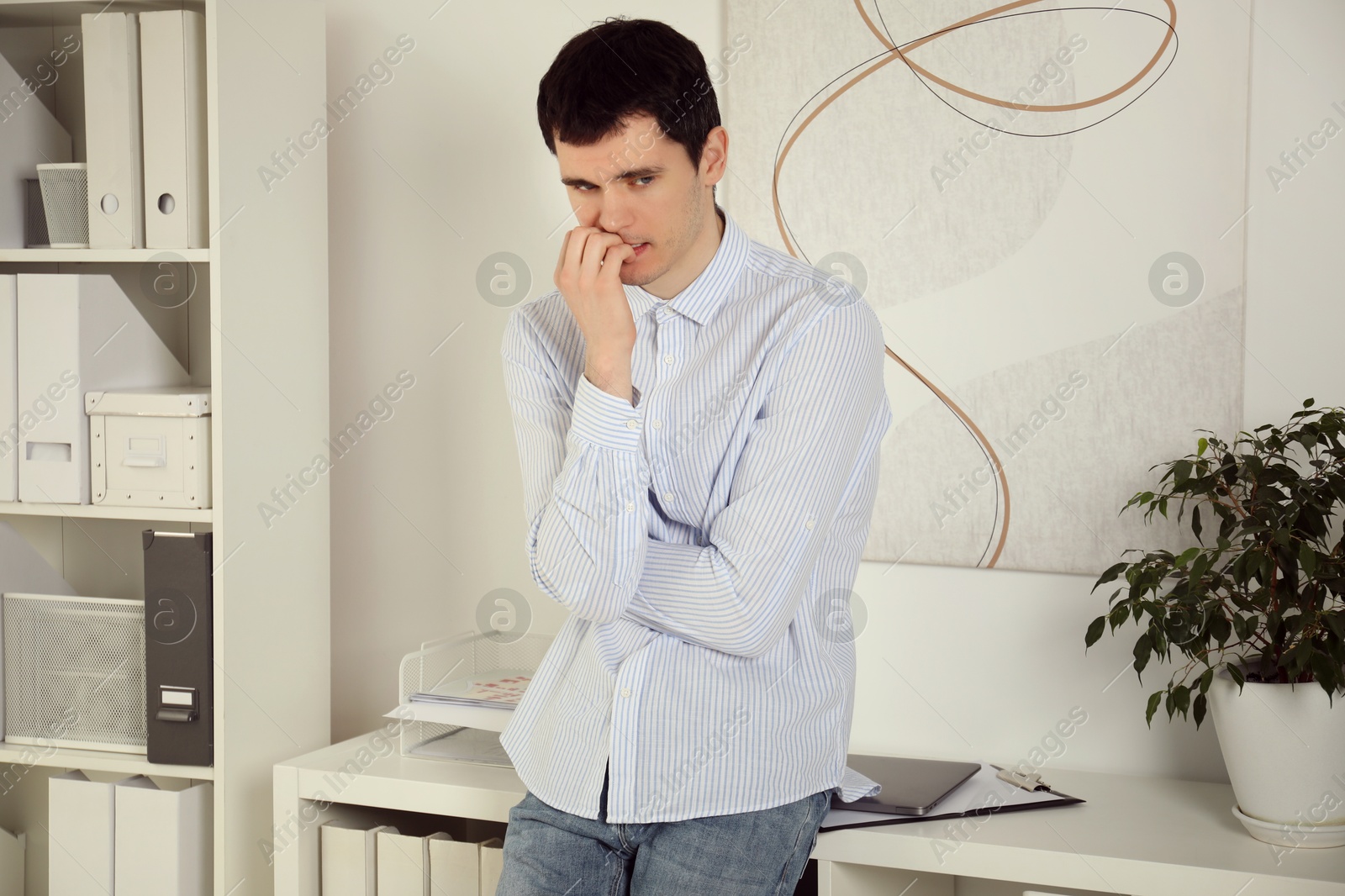 Photo of Portrait of embarrassed young man in office