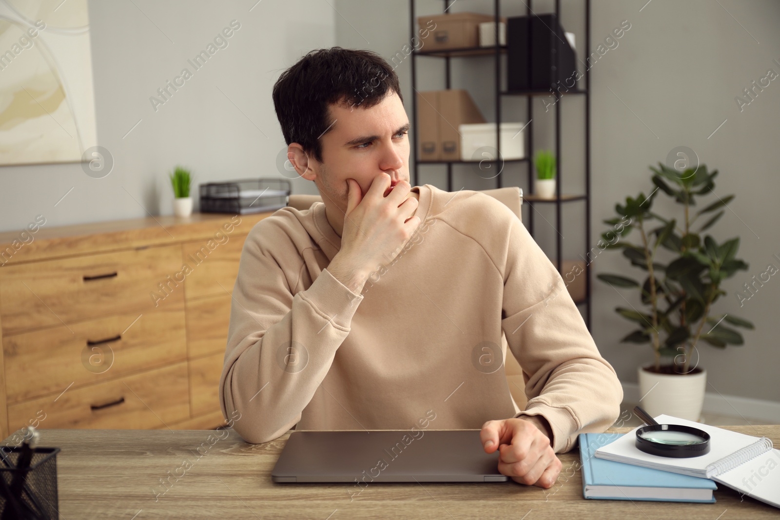 Photo of Embarrassed man at wooden table with laptop in office