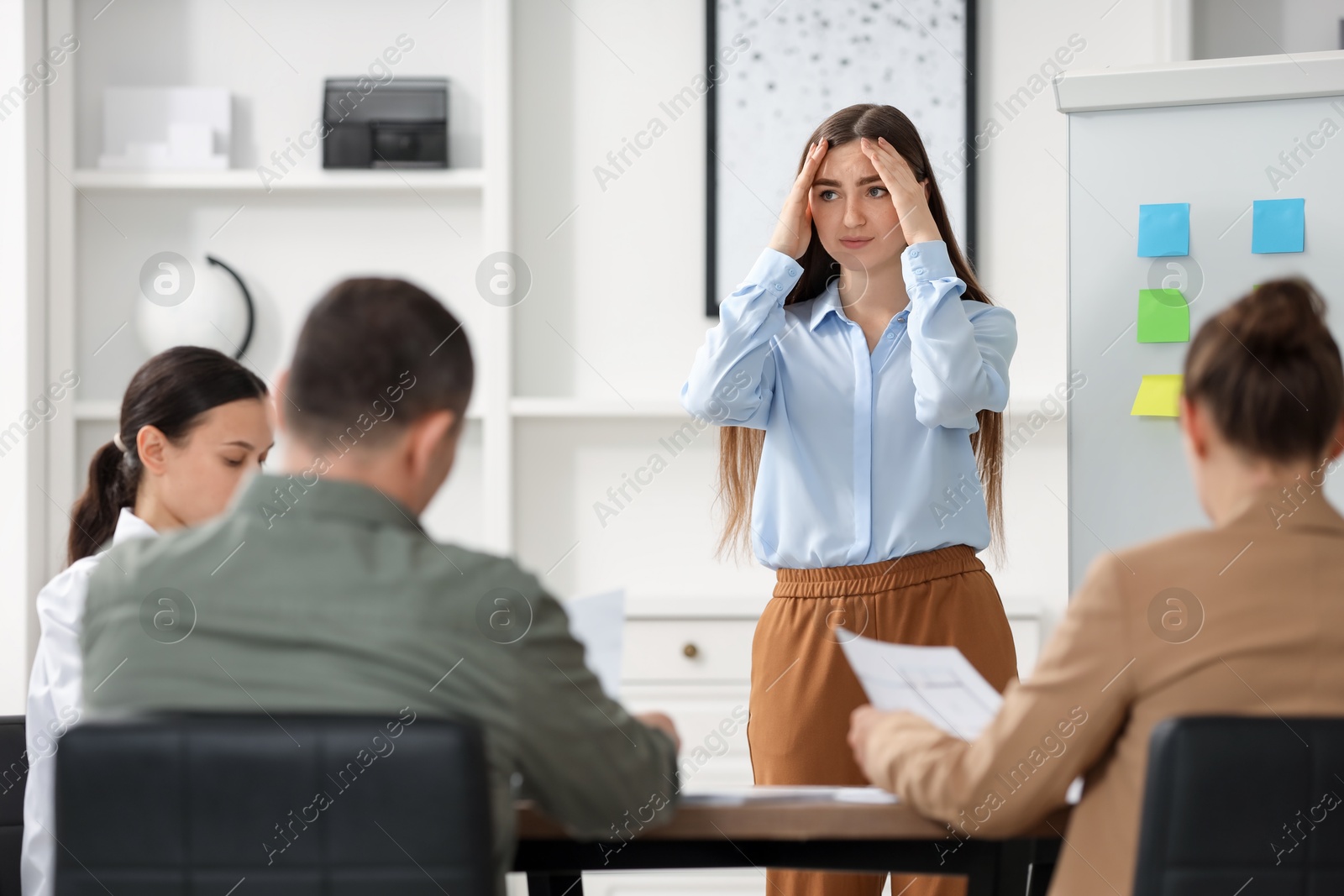 Photo of Woman feeling embarrassed during business meeting in office