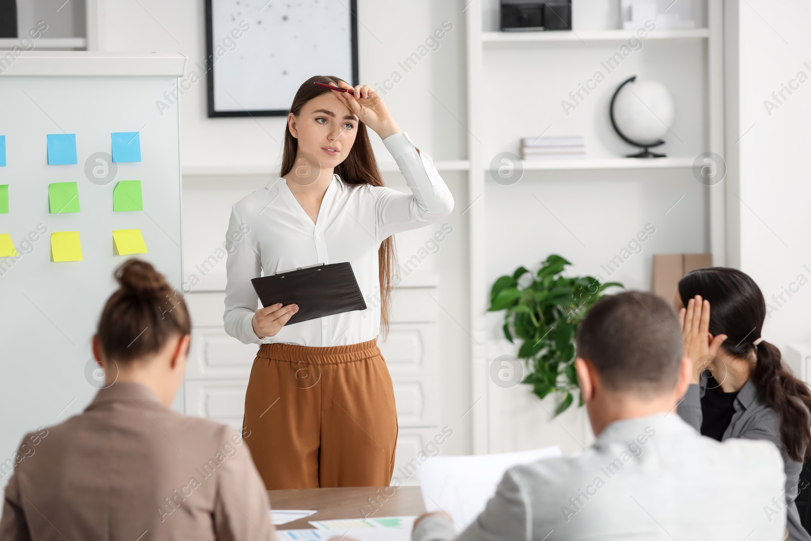 Photo of Woman with clipboard feeling embarrassed during business meeting in office