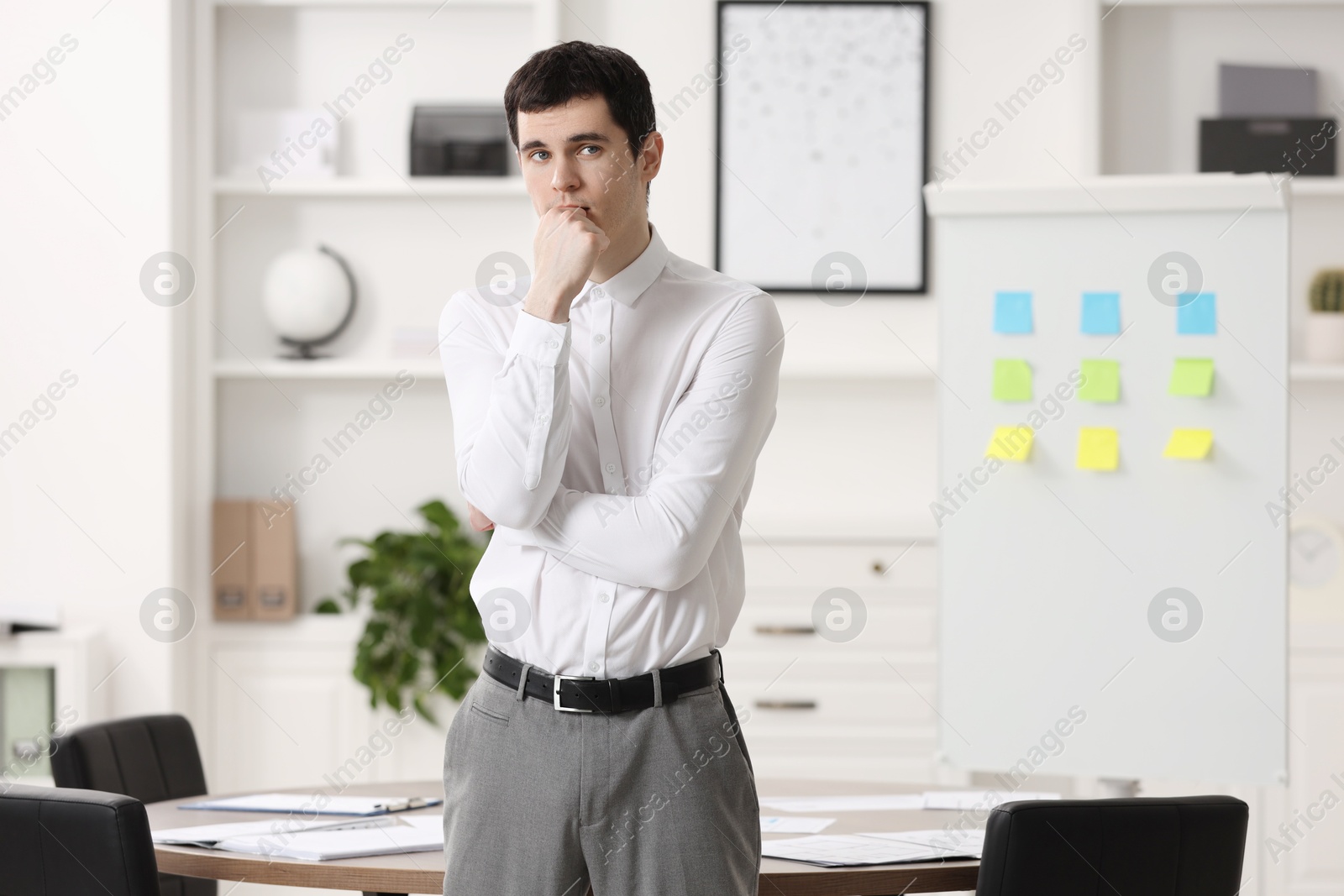 Photo of Portrait of embarrassed young man in office