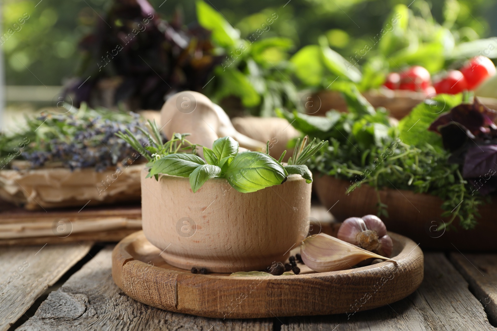 Photo of Different aromatic herbs, mortar with pestle and spices on wooden table, closeup