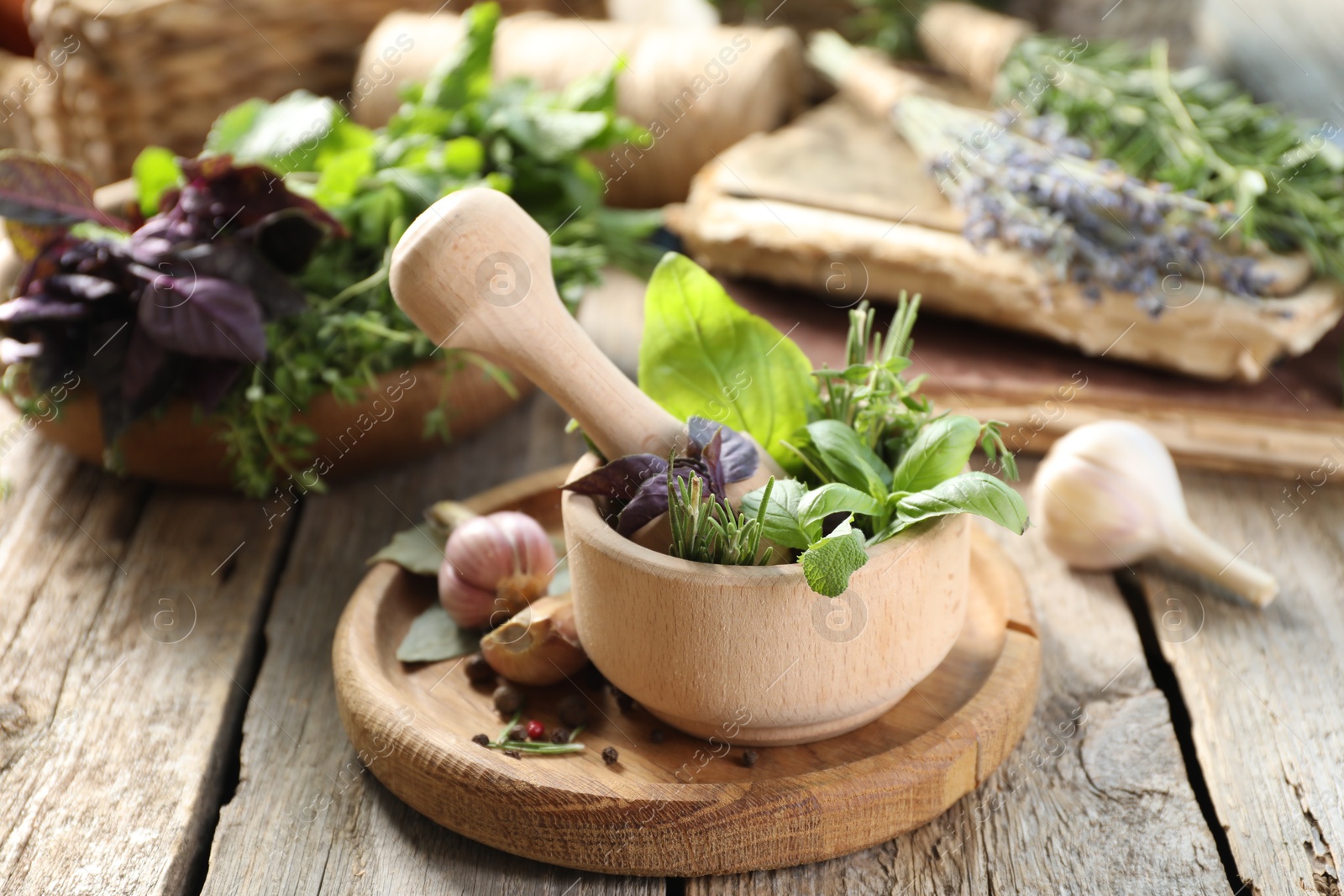 Photo of Different aromatic herbs, mortar with pestle and spices on wooden table, closeup