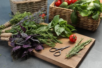 Different aromatic herbs, vegetables and scissors on gray table, closeup