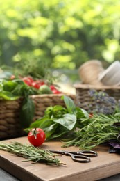 Photo of Different aromatic herbs, vegetables and scissors on table, closeup