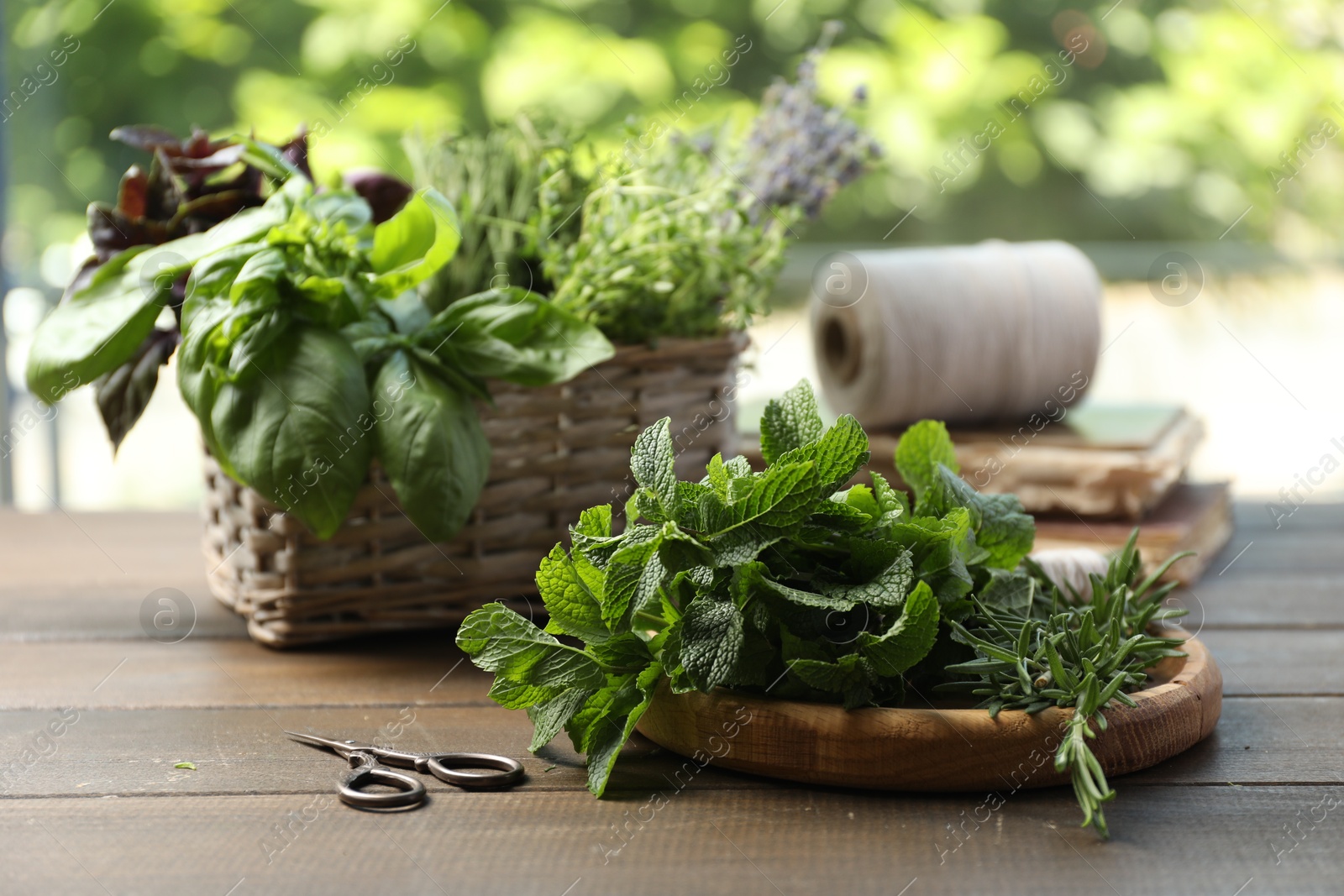 Photo of Different aromatic herbs and scissors on wooden table