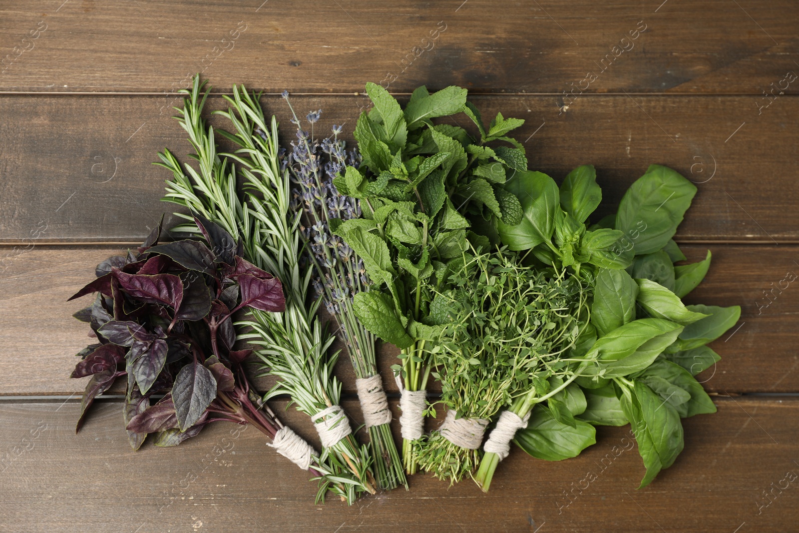 Photo of Different aromatic herbs on wooden table, top view