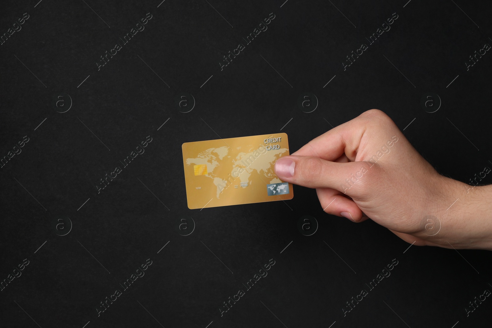 Photo of Man holding credit card on black background, closeup