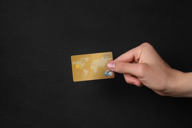 Photo of Man holding credit card on black background, closeup