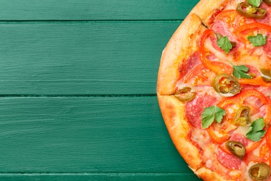 Delicious pizza Diablo on green wooden table, top view. Space for text