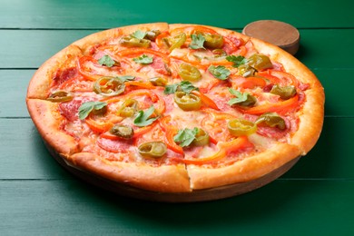 Photo of Delicious pizza Diablo on green wooden table