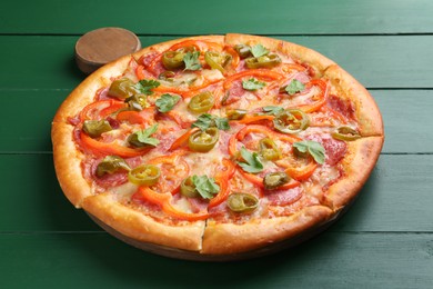 Delicious pizza Diablo on green wooden table