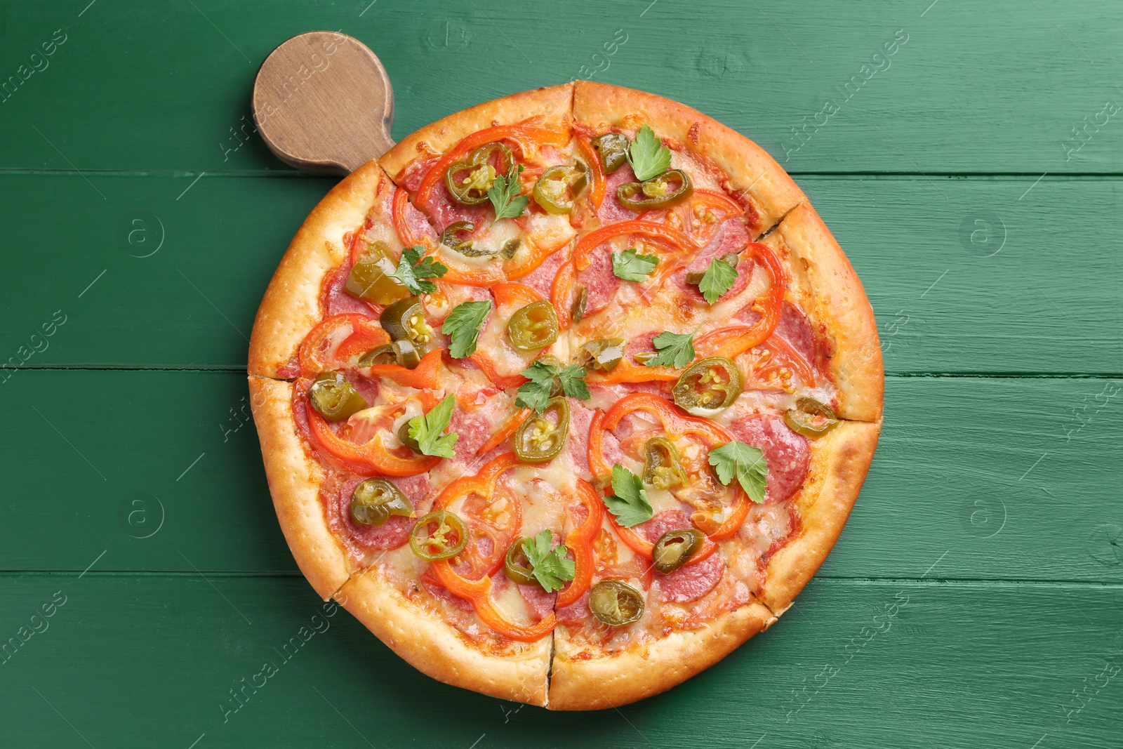 Photo of Delicious pizza Diablo on green wooden table, top view