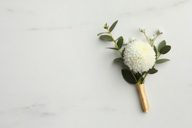 Photo of Small stylish boutonniere on white marble table, top view. Space for text