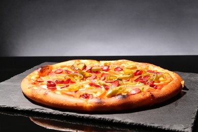 Photo of Delicious pizza Diablo on slate board against grey background