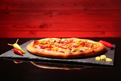 Photo of Delicious pizza Diablo on slate board against red background