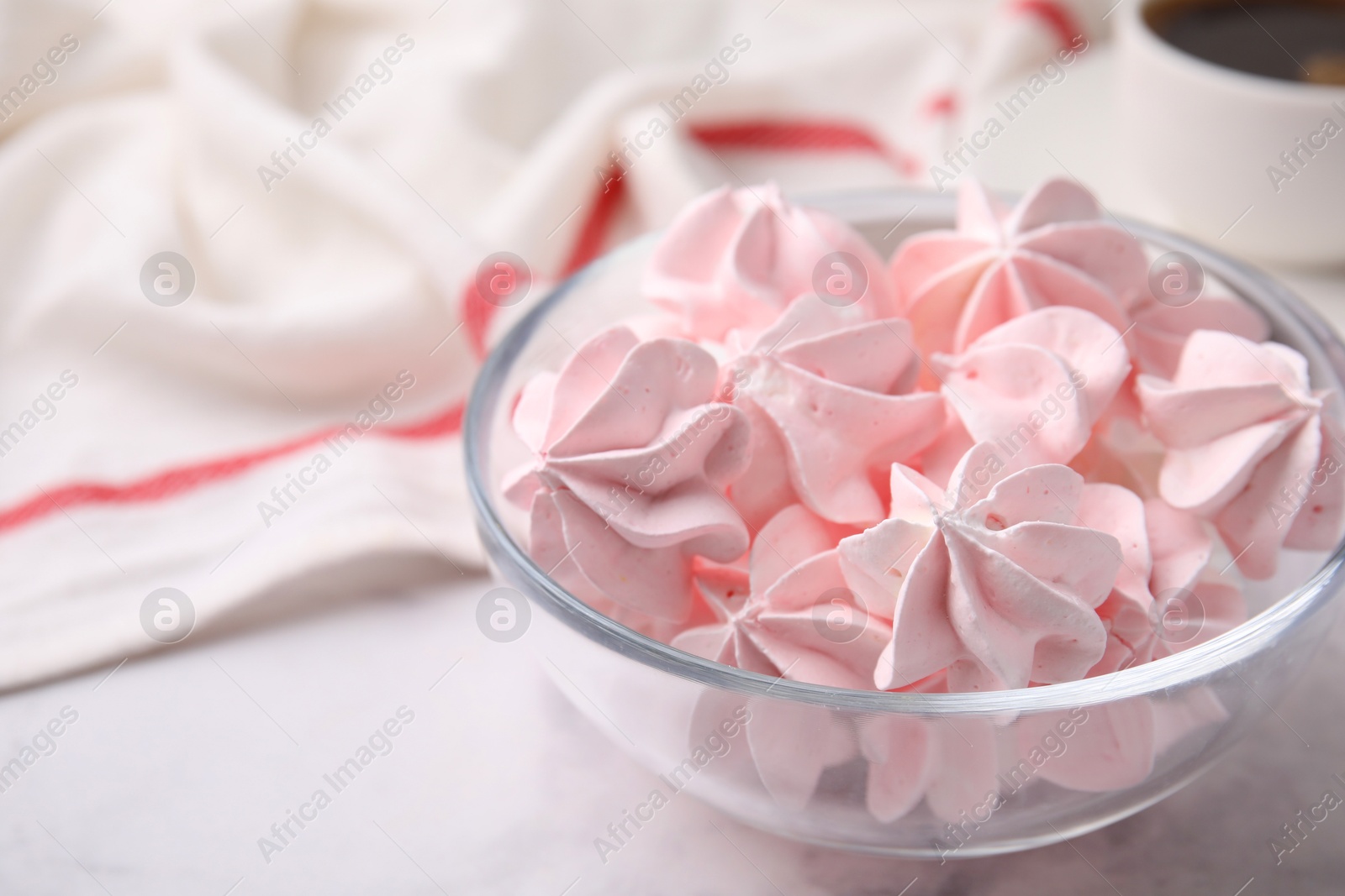 Photo of Tasty meringue cookies in bowl on white marble table, closeup