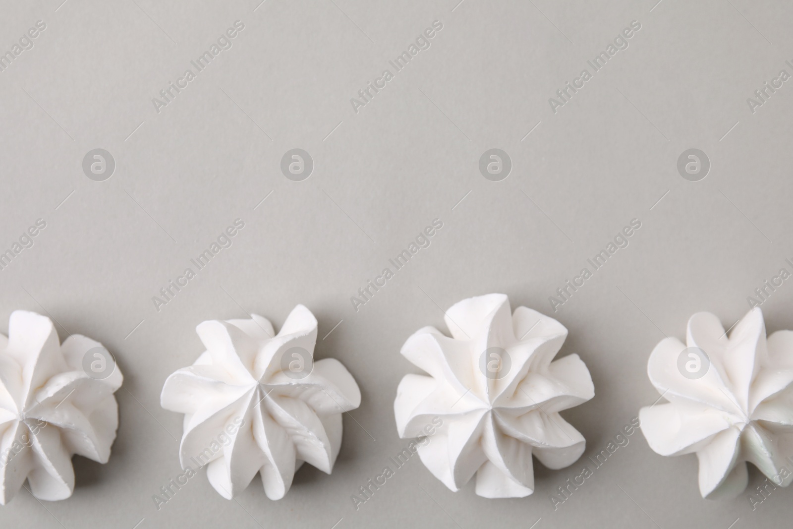 Photo of Tasty meringue cookies on light grey background, flat lay. Space for text