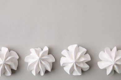 Tasty meringue cookies on light grey background, flat lay. Space for text