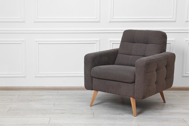 Photo of One soft armchair near white wall indoors. Space for text