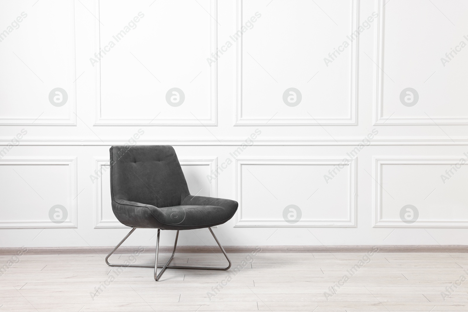 Photo of Soft armchair in light room. Space for text