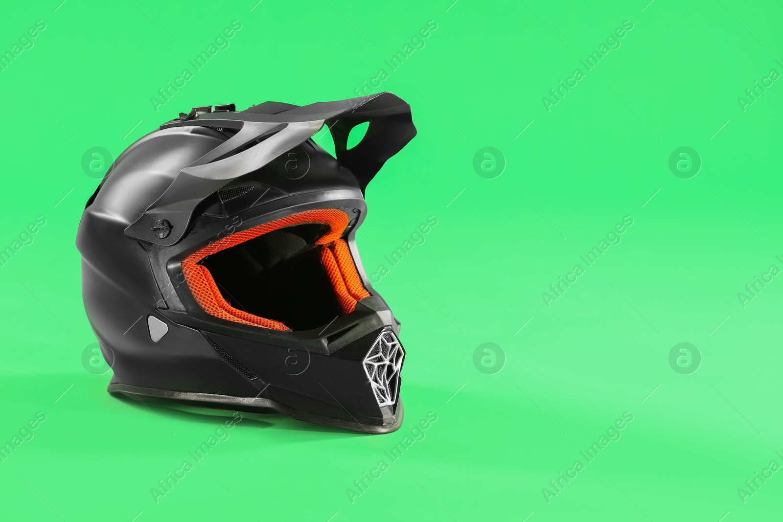 Photo of Modern motorcycle helmet with visor on light green background. Space for text