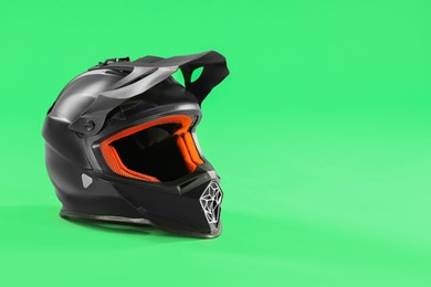 Modern motorcycle helmet with visor on light green background. Space for text