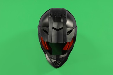 Photo of Modern motorcycle helmet with visor on light green background, top view