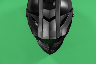 Photo of Modern motorcycle helmet with visor on light green background, top view