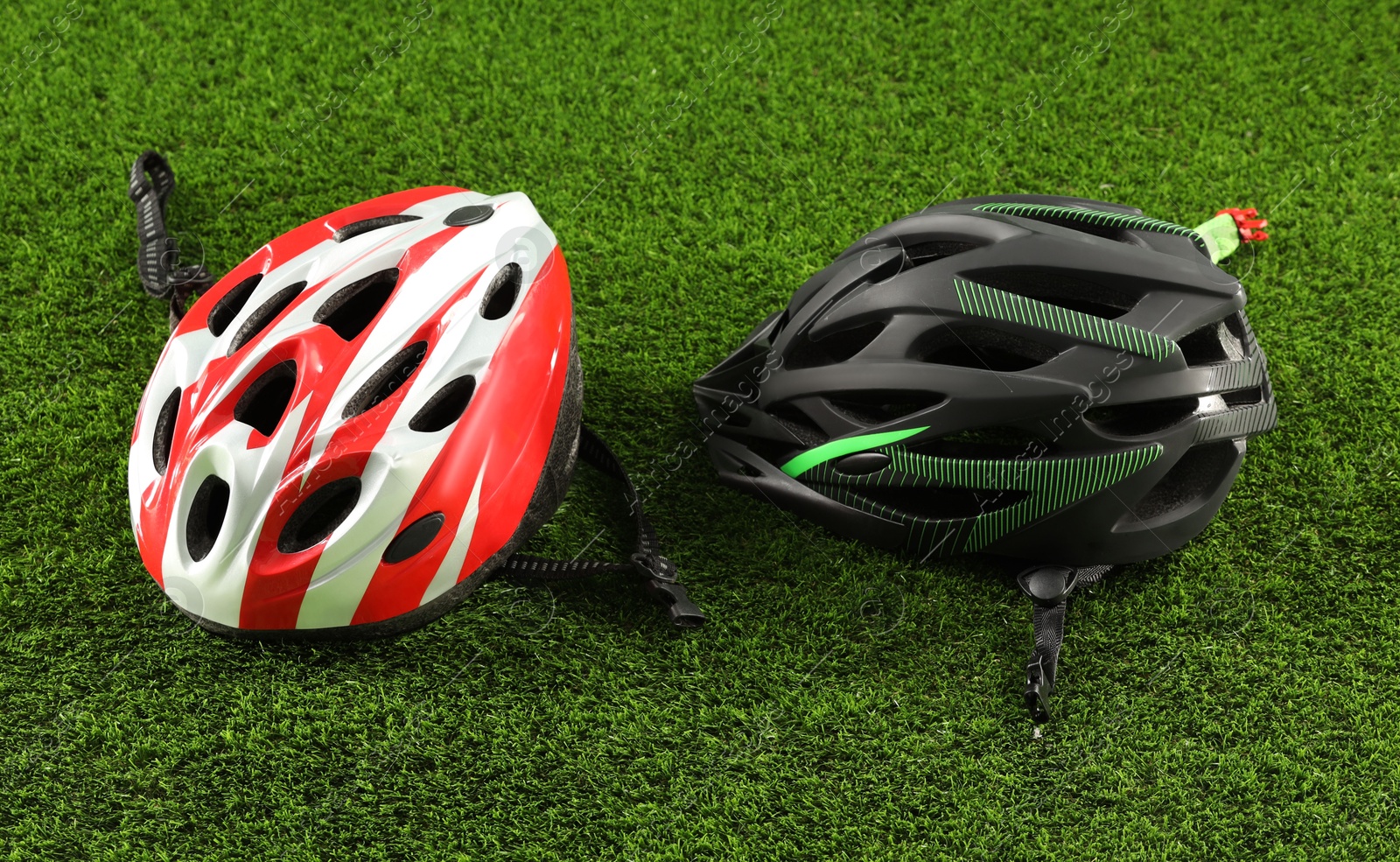 Photo of Two protective helmets on green grass. Sports equipment