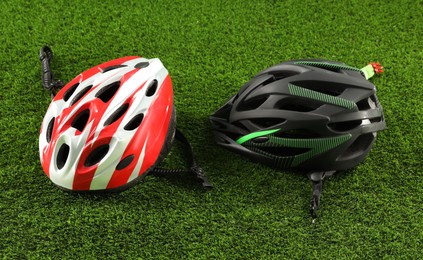 Photo of Two protective helmets on green grass. Sports equipment