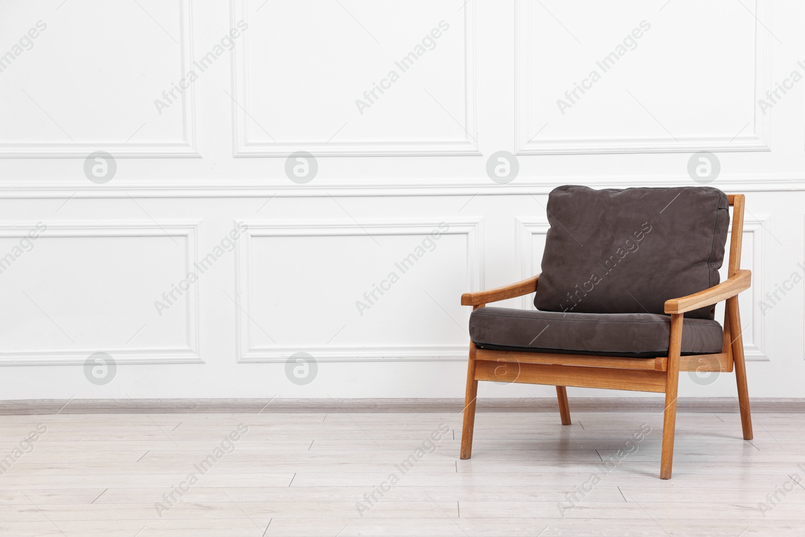 Photo of Comfortable soft armchair near white wall, space for text